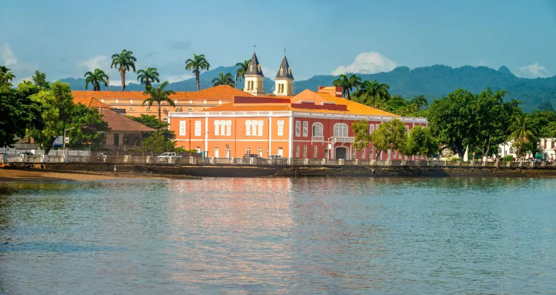 Historic colonial waterfront of São Tomé city with cathedral towers and mountains